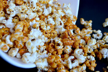 A striped bucket with flying popcorn isolated on a white background.