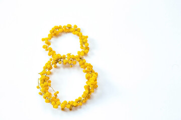 International Women's Day. A banner, a flyer, a beautiful postcard for March 8th. Yellow mimosa flowers in the shape of the number eight on a white isolated background.