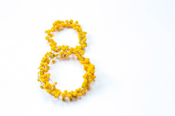 International Women's Day. A banner, a flyer, a beautiful postcard for March 8th. Yellow mimosa flowers in the shape of the number eight on a white isolated background.