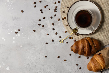 Cup of coffee and croissants on a light gray background.Copy space
