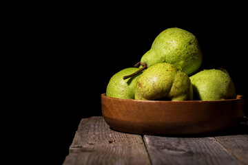 Pears on a wooden table on a black background