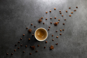 Flat lay a cup of coffee and beans on the dark gray background