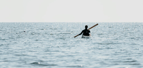 Woman sea kayak. Happy smiling woman in kayak on ocean, paddling with wooden oar. Calm sea water...