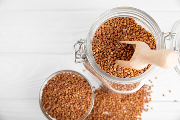 Raw buckwheat in a bowl on a textured wooden background. Wheat grains, porridge, cereals, raw buckwheat in a plate. Healthy food. Porridge. Diet. Organic cerea. Space for text.Copy space.