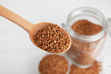 Raw buckwheat in a bowl on a textured wooden background. Wheat grains, porridge, cereals, raw buckwheat in a plate. Healthy food. Porridge. Diet. Organic cerea. Space for text.Copy space.