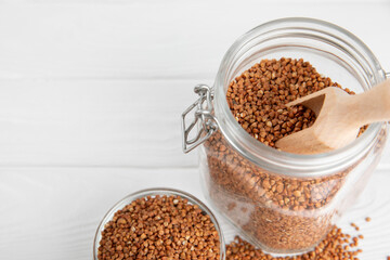 Raw buckwheat in a bowl on a textured wooden background. Wheat grains, porridge, cereals, raw buckwheat in a plate. Healthy food. Porridge. Diet. Organic cerea. Space for text.Copy space.