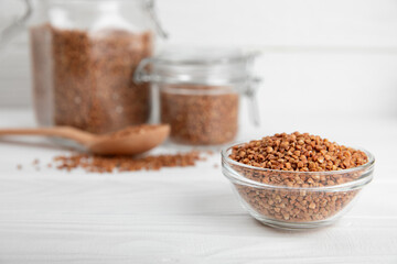 Raw buckwheat in a bowl on a textured wooden background. Wheat grains, porridge, cereals, raw buckwheat in a plate. Healthy food. Porridge. Diet. Organic cerea. Space for text.Copy space.
