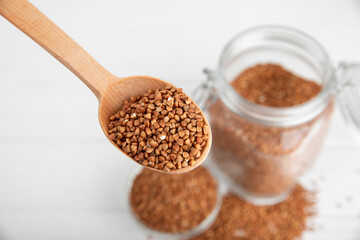 Raw buckwheat in a bowl on a textured wooden background. Wheat grains, porridge, cereals, raw buckwheat in a plate. Healthy food. Porridge. Diet. Organic cerea. Space for text.Copy space.