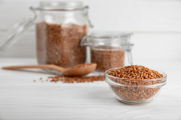 Raw buckwheat in a bowl on a textured wooden background. Wheat grains, porridge, cereals, raw buckwheat in a plate. Healthy food. Porridge. Diet. Organic cerea. Space for text.Copy space.