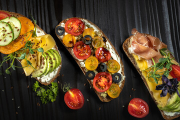 Open sandwiches with cherry tomato,avocado, cheese,bacon and olive.Top view