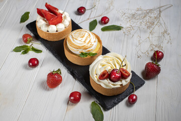 Fototapeta na wymiar Tasty tartlets with berries on white background.Dessert photo.High angle