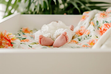 Fototapeta na wymiar Adorable baby feet with tiny toes, nestled in a floral blanket on a peaceful nursery bed, capturing the essence of new life and innocence.