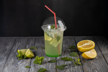 Lemonade in a plastic cup.Non alcoholic beverage with lemon and mint