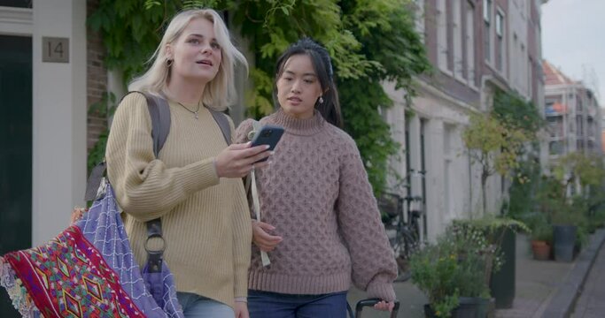 Female Tourists Looking for directions using Phone In Amsterdam, the Netherlands