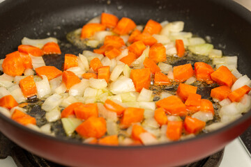 Finely chopped onions and fresh carrots are fried in butter, pate preparation