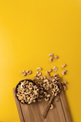 Cashew nuts on a yellow background.Vertical format.Copy space