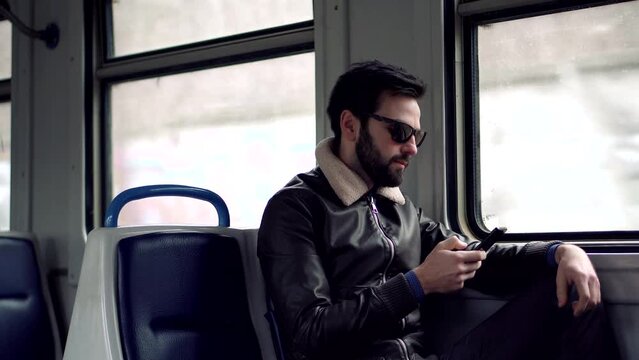 Man texting on smartphone on train . Man texting on mobile phone 