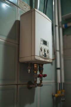 A water heater mounted on the wall in a bathroom. Ideal for providing hot water in residential or commercial settings