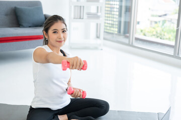 Fototapeta na wymiar Fresh feeling female training and exercise wearing sport wear fit body. Attractive asian young fitness woman lifting dumbbell weights workout at home in living room