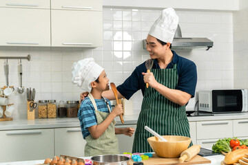 Happy moment asian father and son cooking breakfast in the kitchen. Dad and child asian family...