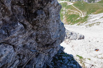 Scenic via ferrata hiking trail to mount Mangart (Mangrt), Julian Alps, Friuli Venezia Giulia, Italy, Europe. Climbing through treacherous rugged mountainscape amidst extreme alpine terrain in summer - obrazy, fototapety, plakaty