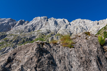 Scenic hiking trail from Fusine Lake to Mangart saddle in Tarvisio, Julian Alps, Friuli Venezia Giulia, Italy, Europe. Rugged mountain rock formations on extreme alpine terrain in summer. Wanderlust