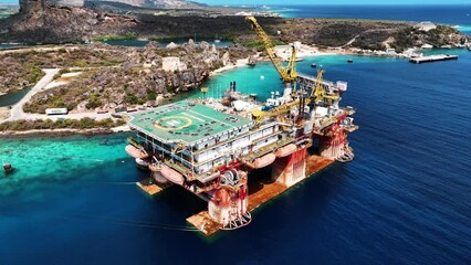 The drone is flying around an oil platform at the Caracas Bay Curacao Aerial Footage 4K