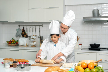 Young handsome asian man chef cooking breakfast in the kitchen. Happy asian man preparing food with ingredient. Chef in uniform in the kitchen.