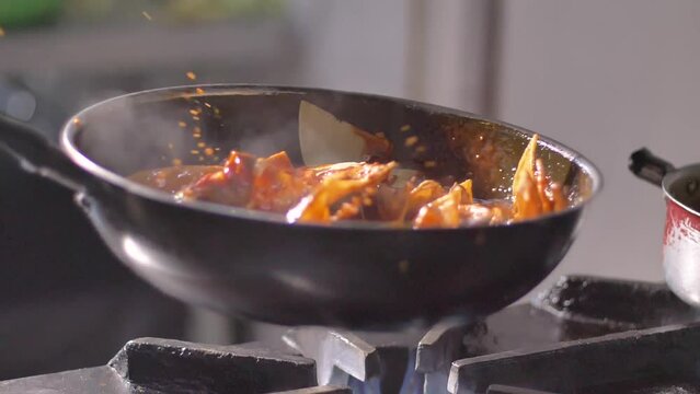 Tortilla chips with hot salsa in frying pan on burning fire in slow motion. Cooking enchiladas on pan