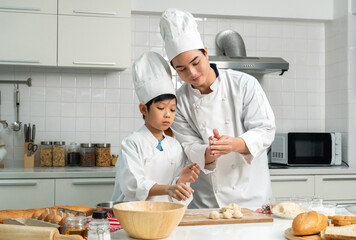 Young handsome asian man chef cooking breakfast in the kitchen. Happy asian man preparing food with ingredient. Chef in uniform in the kitchen.