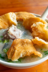 angle view fish porridge with deep-fried Chinese donuts at vertical composition
