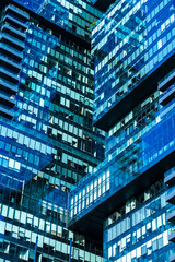 From below of contemporary high rise buildings with glass mirrored windows located on street of city