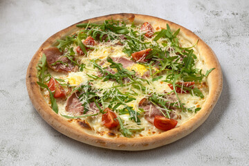 Tasty italian pizza with arugula,cherry tomatoes,egg,bacon.Isolated on gray background