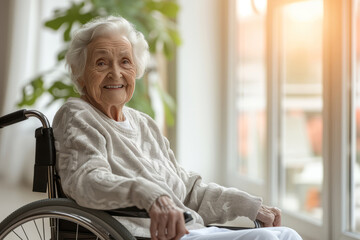 Cheerful old woman in a retirement home. Senior lady in a wheelchair laughing happily in a nursing home. Housing facility intended for the elderly people. - obrazy, fototapety, plakaty