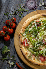 Close up caesar pizza with salad,cherry tomatoes and chicken meat .Vertical format