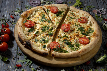 Appetizing sliced pizza with cherry tomatoes,basel and species.Close up