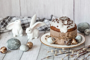 Obraz na płótnie Canvas Stylish grey Easter eggs in the colors of marble, concrete, willow branches, Easter bunnies and Easter cake on a white wooden background. Coloring eggs for Easter. The feast of bright Easter.
