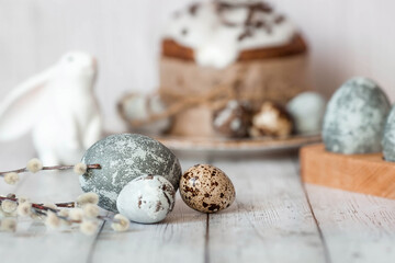 Obraz premium Stylish grey Easter eggs in the colors of marble, concrete, willow branches, Easter bunnies and Easter cake on a white wooden background. Coloring eggs for Easter. The feast of bright Easter.