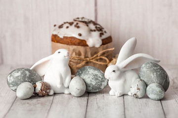 Fototapeta na wymiar Stylish grey Easter eggs in the colors of marble, concrete, willow branches, Easter bunnies and Easter cake on a white wooden background. Coloring eggs for Easter. The feast of bright Easter.
