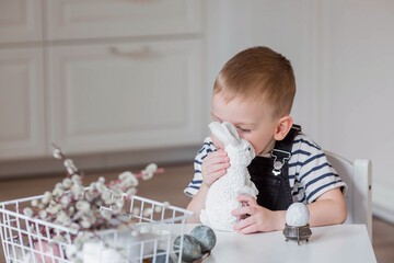 A little boy and a white Easter bunny. We are preparing the family for a Bright Easter. A child is...