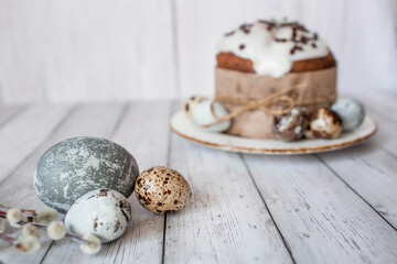 Stylish grey Easter eggs in the colors of marble, concrete, willow branches, Easter bunnies and Easter cake on a white wooden background. Coloring eggs for Easter.  The feast of bright Easter.