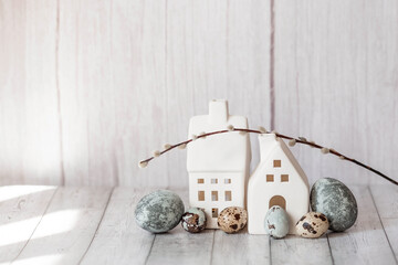 Stylish grey Easter eggs in the colors of marble, concrete, willow branches and white houses in...