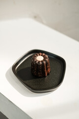 Canele cake, French dessert on black plate