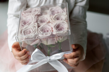 flower box with pink roses in child's hands