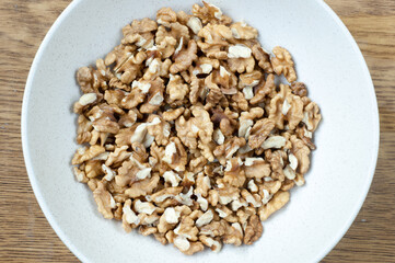 Pile of walnuts on a white plate. Top view