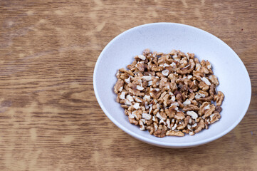 Pile of walnuts on a white plate. Top view. Copy space