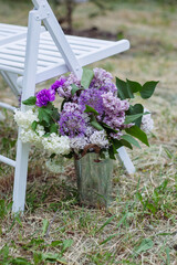 Blooms in Harmony: Lilac Peonies, Giant Onions, and Carnations Adorn a Decorative Bucket, Elevating Outdoor Events and Weddings with Fresh Floral Elegance. - 706327685