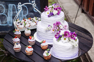 Wedding cakes and cupcakes on a candy bar. - 706328032