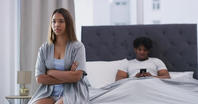 Frustrated couple, bed and argument with phone in conflict, disagreement or divorce from fight at home. Upset woman or man ignore sitting on mobile smartphone in cheating affair or breakup in bedroom