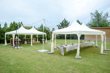 Large folding white tents at a wedding party. Place for wedding banquet outdoor - 706328671